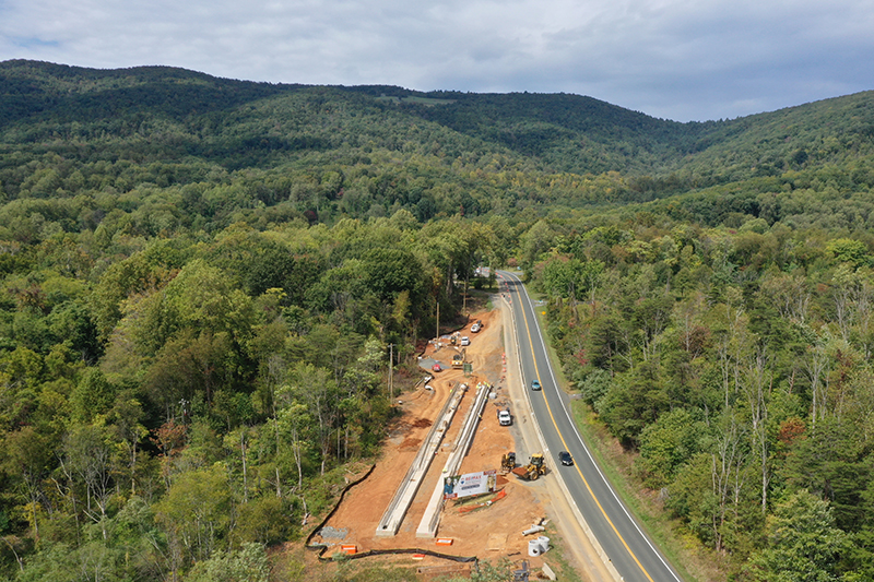 Aerial view of construction for a truck arrestor ramp alongside the downhill lane of a roadway in Albemarle County.